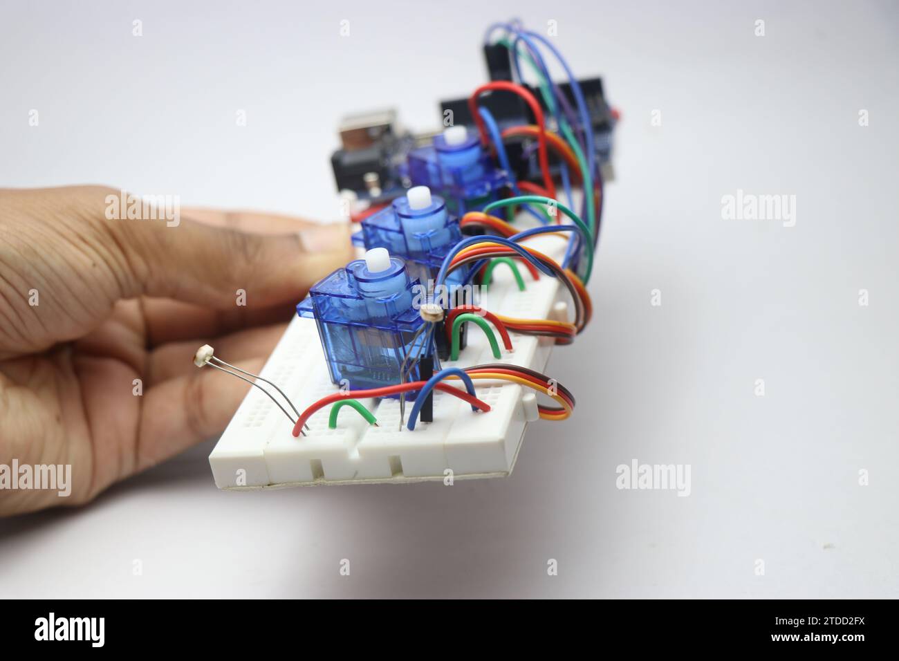 Breadboard con fili e microservomotori collegati a un chip elettronico Foto Stock