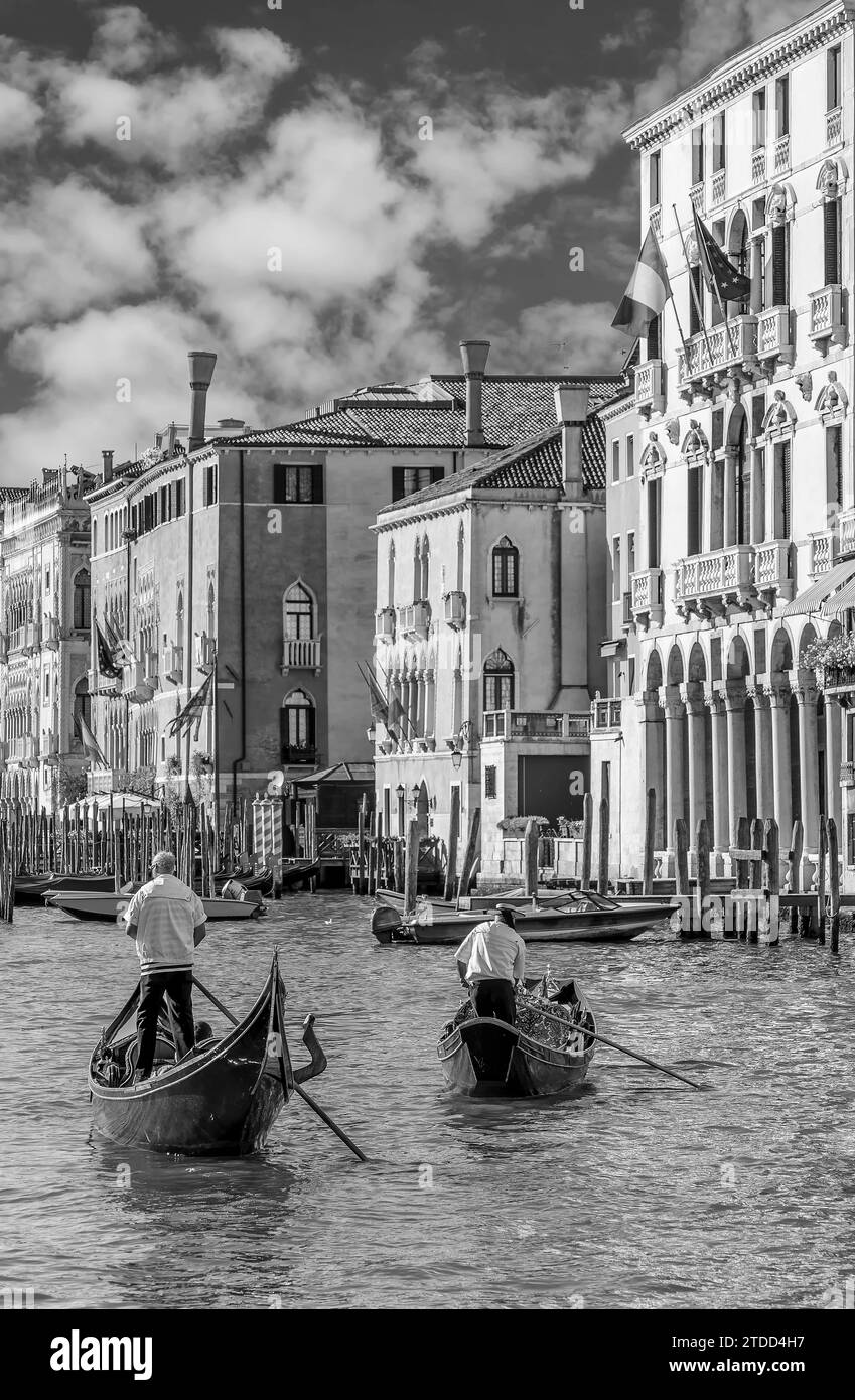 Due gondolieri attraversano il famoso Canal grande a Venezia, in Italia, in bianco e nero Foto Stock