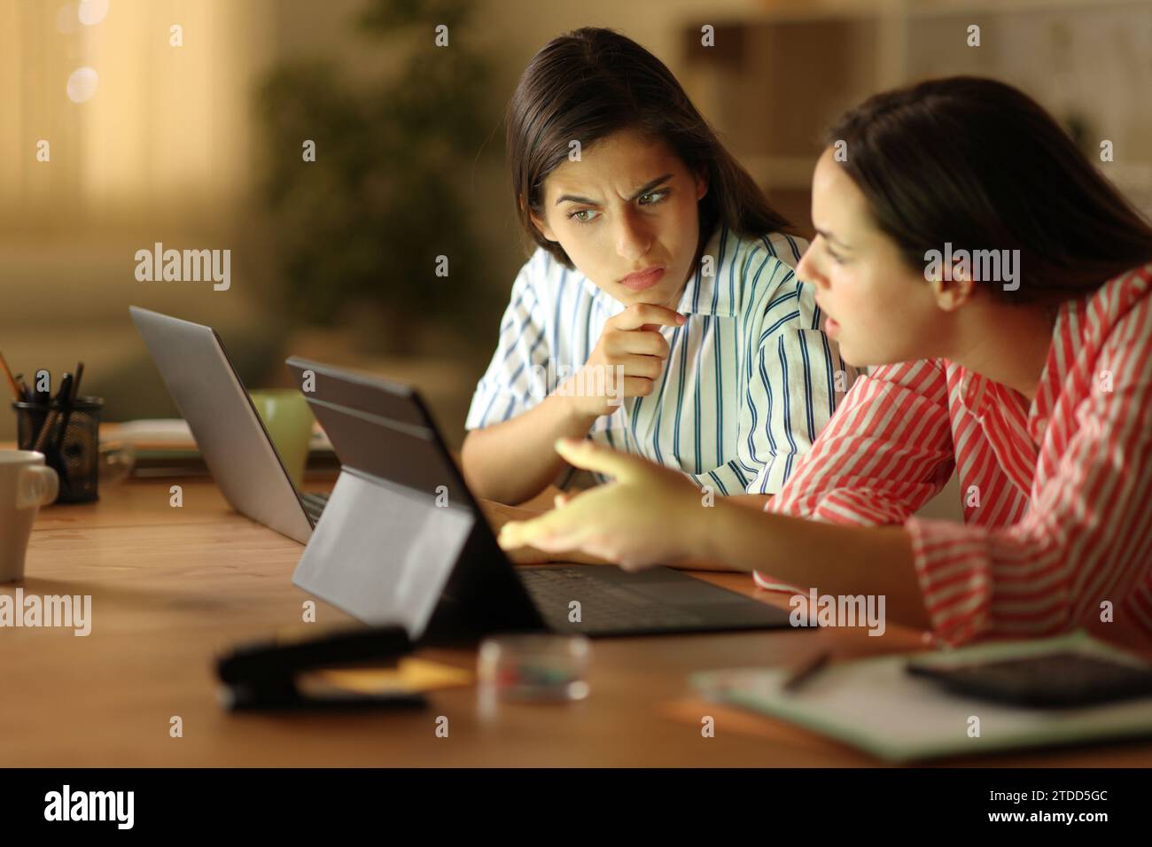 I telelavoratori sospetti che lavorano online a casa controllando i contenuti online sui notebook Foto Stock
