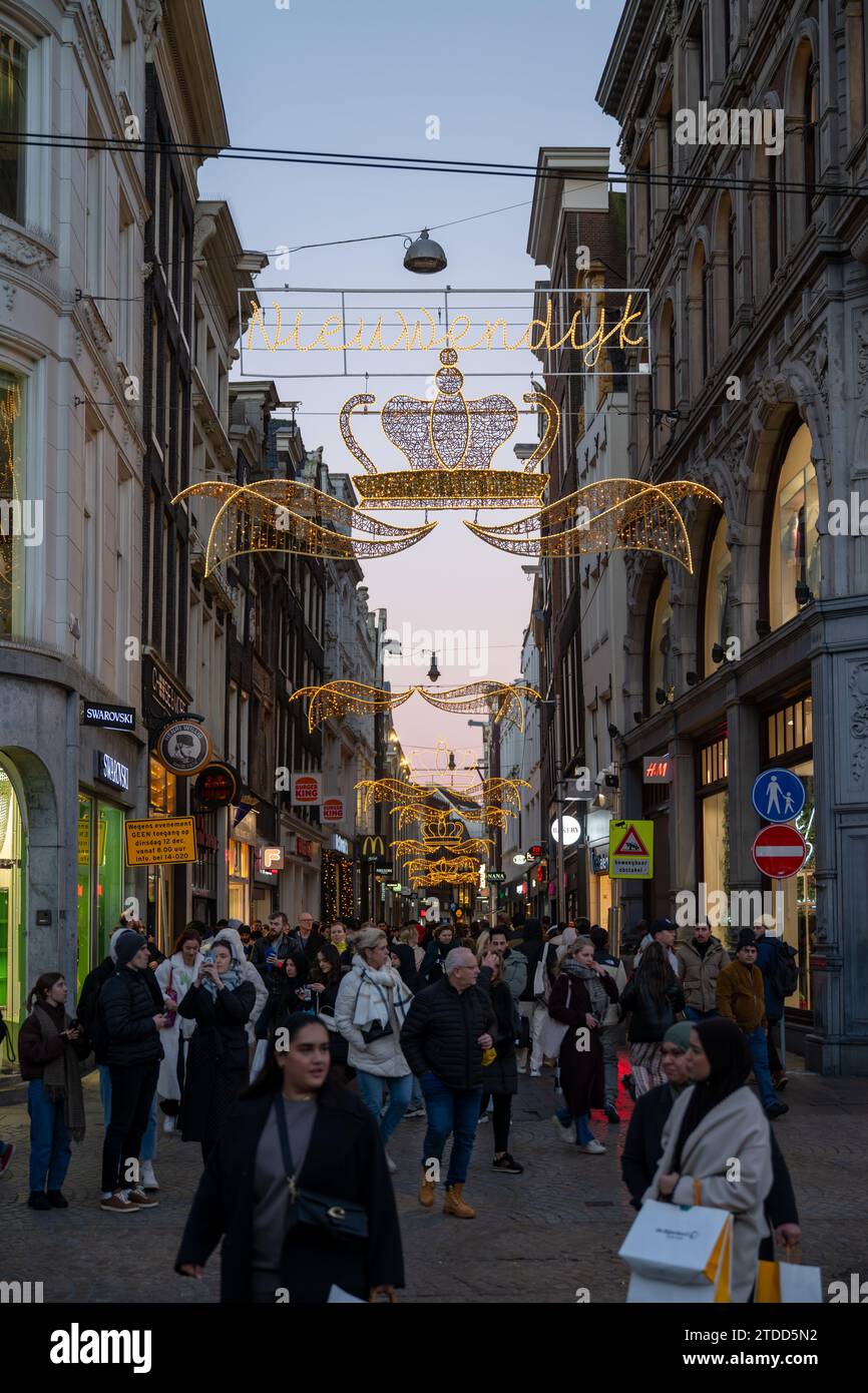 Amsterdam, Paesi Bassi - 17 dicembre 2023: Turisti e abitanti del luogo nella trafficata strada dello shopping Niewendijk nel centro storico di Amsterdam Foto Stock