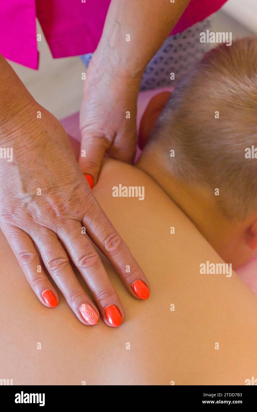 Massaggio naturopatico in uno studio di terapia naturale. Il terapeuta utilizza tecniche olistiche per promuovere il relax e il benessere. Foto Stock