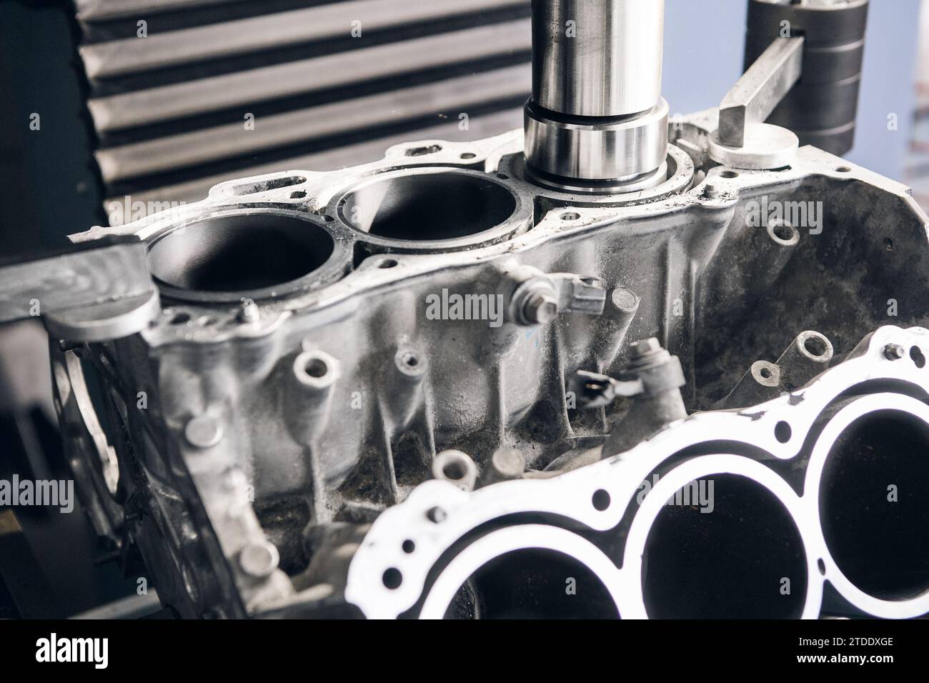Riparazione del motore a tre cilindri su macchine CNC, alesatura sotto il pistone mediante macchina a controllo numerico computerizzato. Foto Stock