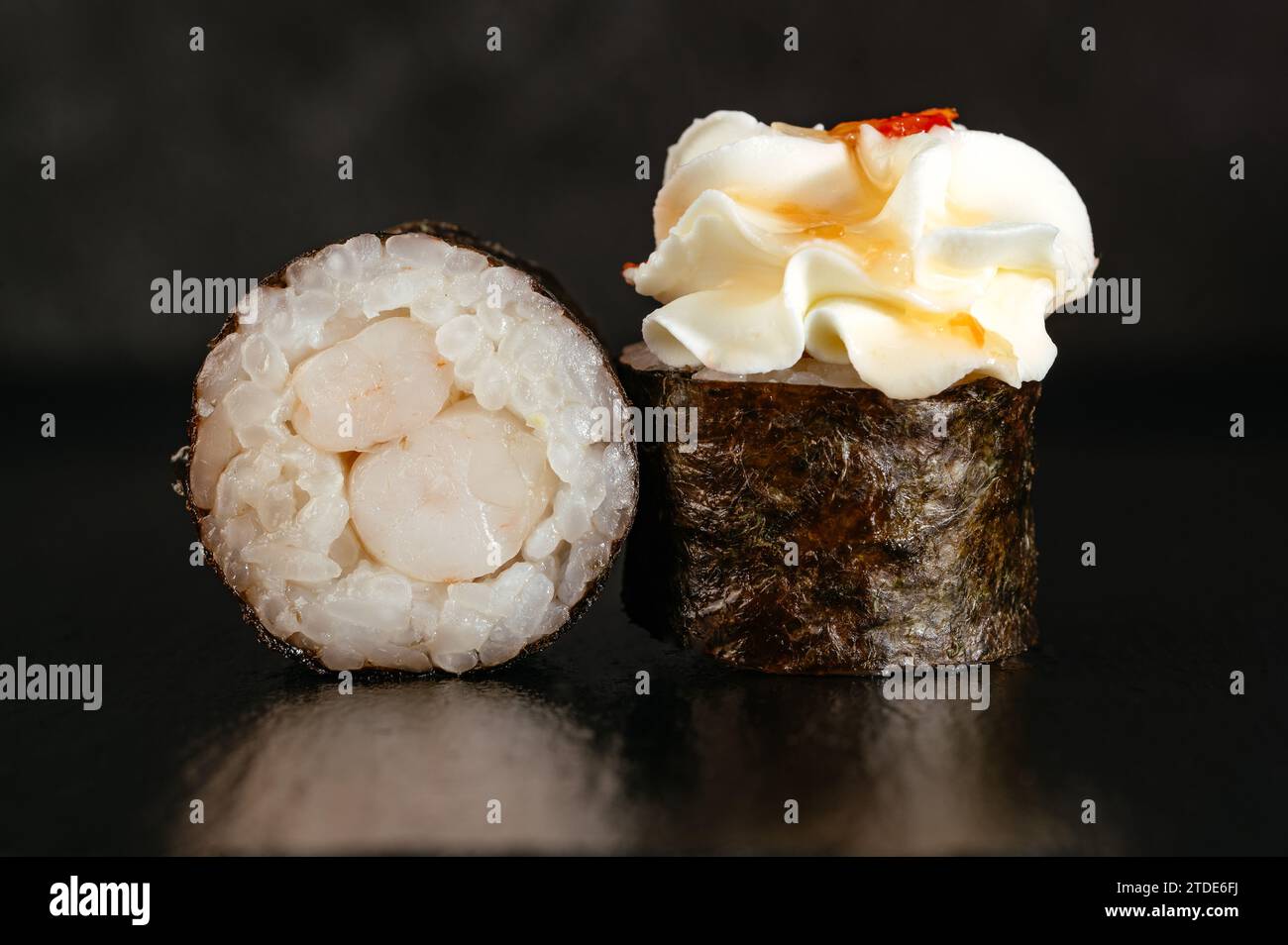 Involtini di sushi giapponesi con un tappo di formaggio su sfondo scuro con Foto Stock