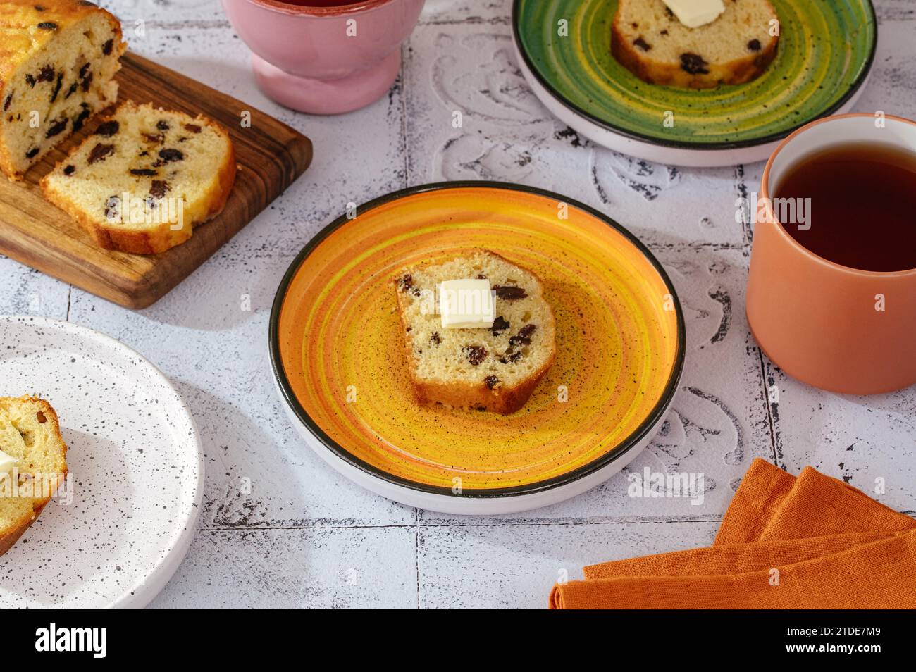 cupcake fatto in casa con uvetta su un piatto con un pezzo di burro Foto Stock