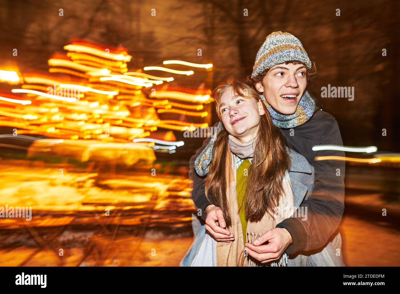 un ragazzo e una ragazza felici che ingannano nel parco notturno Foto Stock
