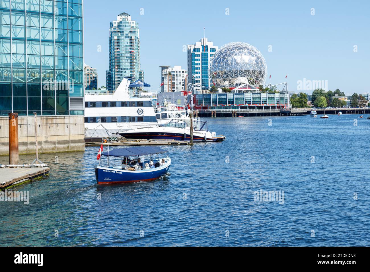 Vancouver, Canada - luglio 1,2023: Vista della nave False Creek Ferries piena di passeggeri in una giornata di sole con zscience World sullo sfondo Foto Stock