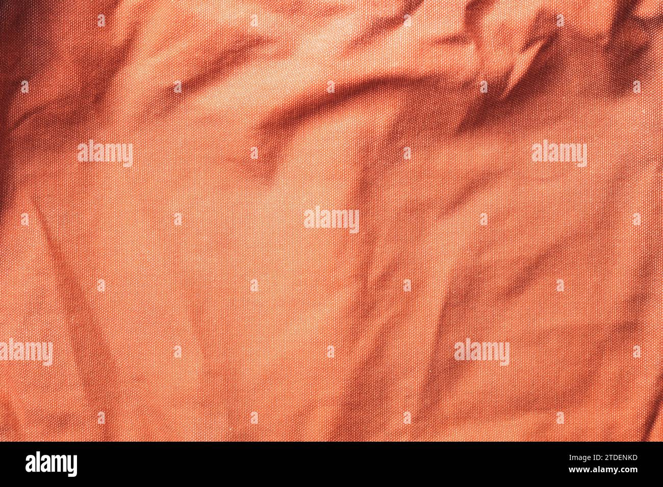 Trama del vecchio materiale tessile sgualcito nel colore peach fuzz, vista dall'alto Foto Stock