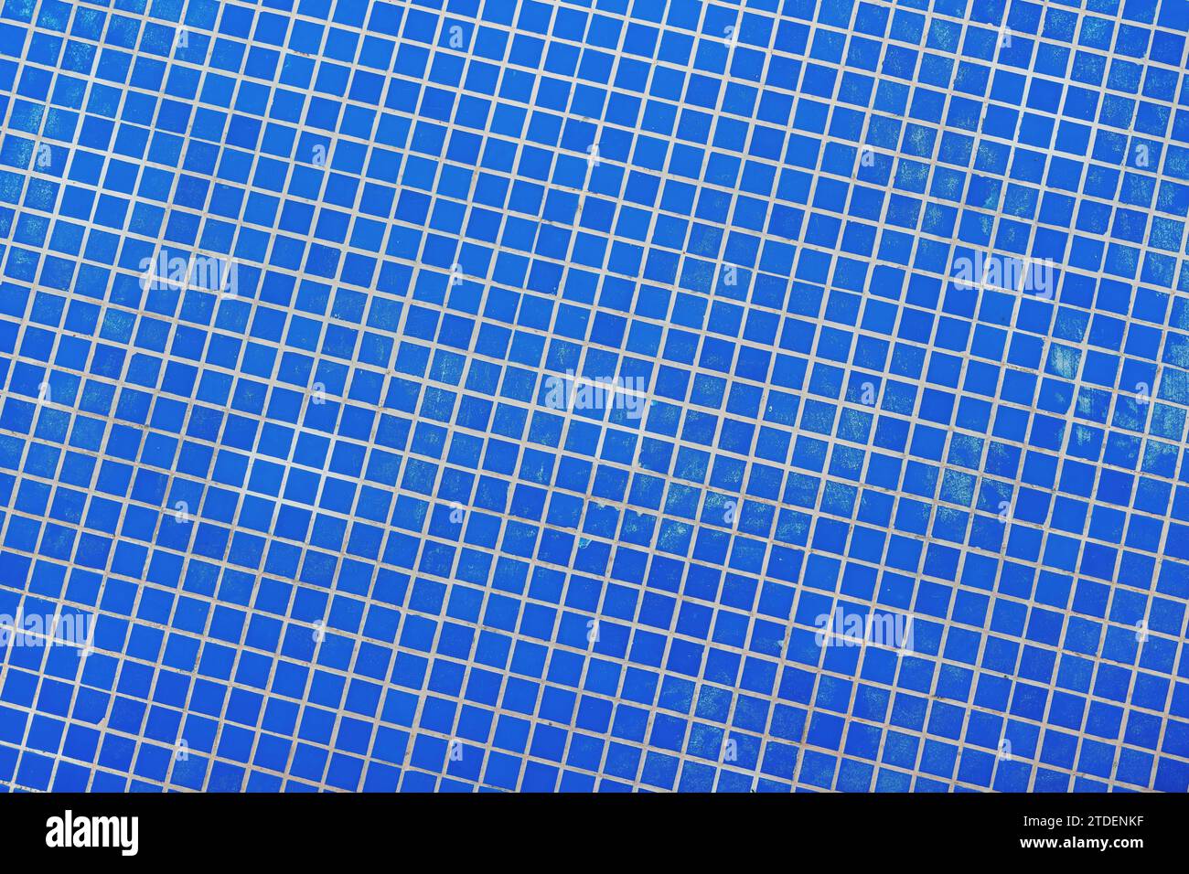 Piccole piastrelle di ceramica blu nella piscina esterna con fontana come sfondo e motivo Foto Stock