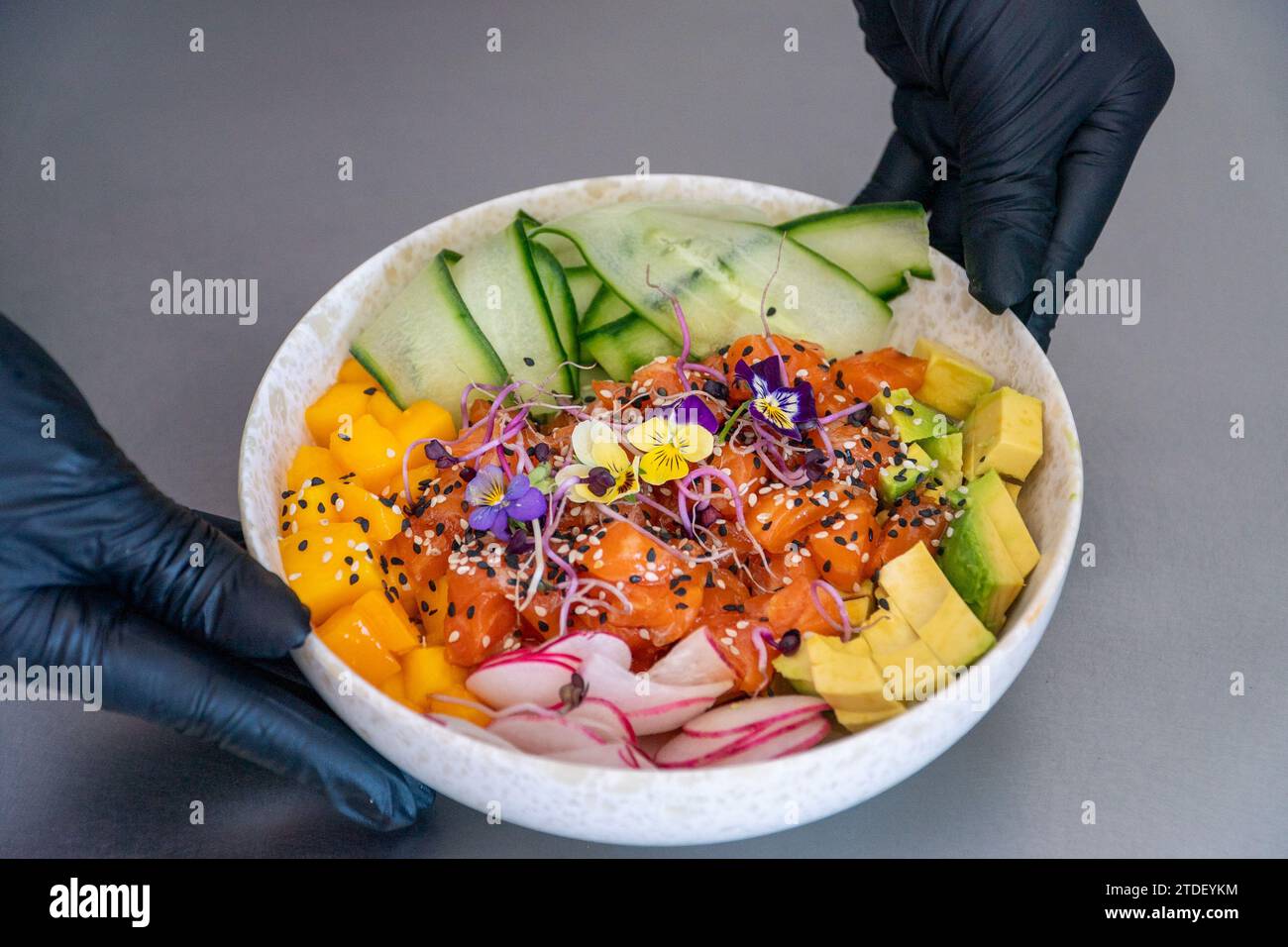un'immagine paesaggistica di uno chef che presenta una ciotola di salmone preparata al momento Foto Stock