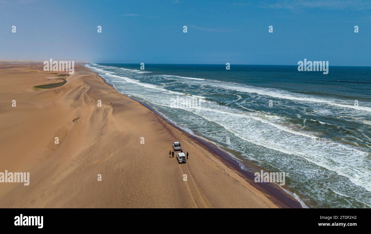 Auto che guidano sulla cresta delle dune di sabbia lungo l'Atlantico, nel deserto del Namibe (Namib), nel Parco Nazionale di Iona, nel Namibe, in Angola, Africa Foto Stock