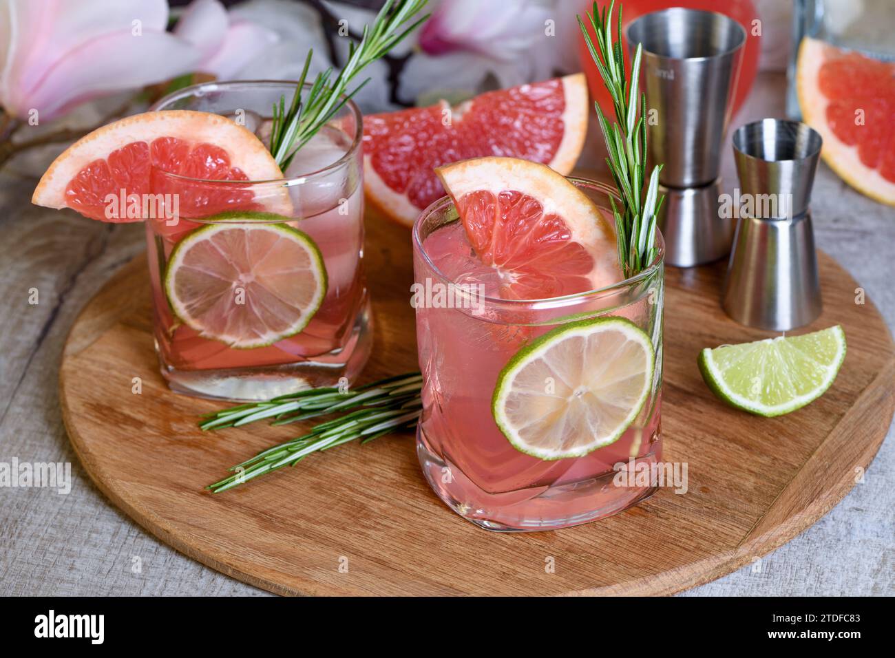 Cocktail biologico rinfrescante con fetta di pompelmo, lime e ramoscello di rosmarino in un bicchiere Foto Stock