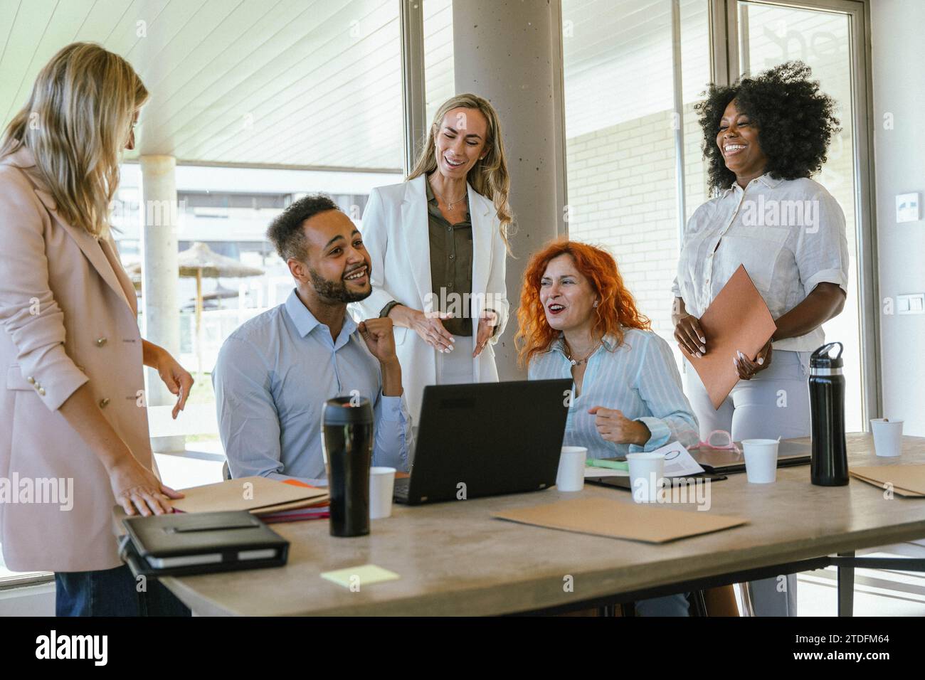 Colleghi d'affari multietnici sorridenti mentre lavorano in ufficio. Concetto aziendale. Foto Stock
