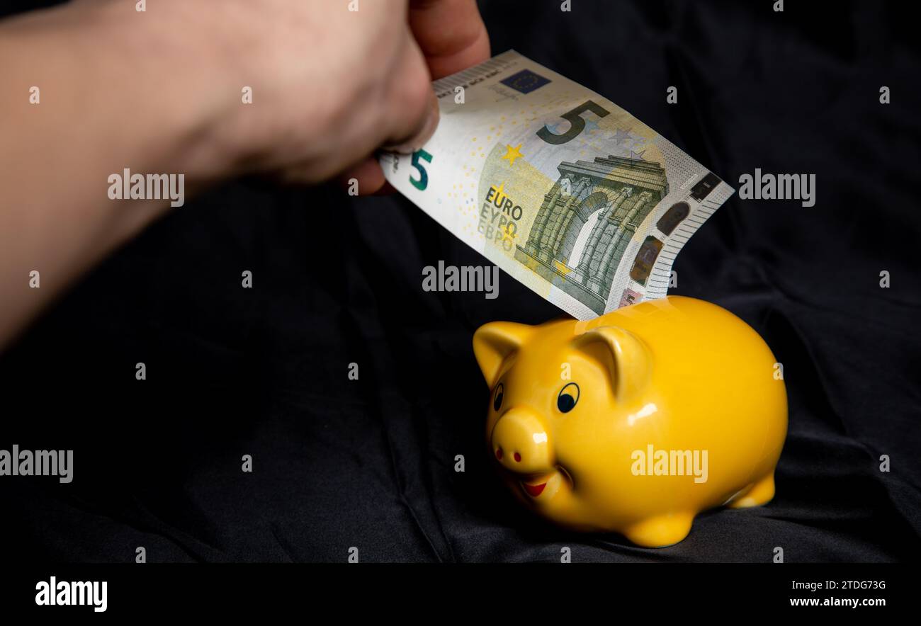 Sparschwein mit Geld füllen Foto Stock