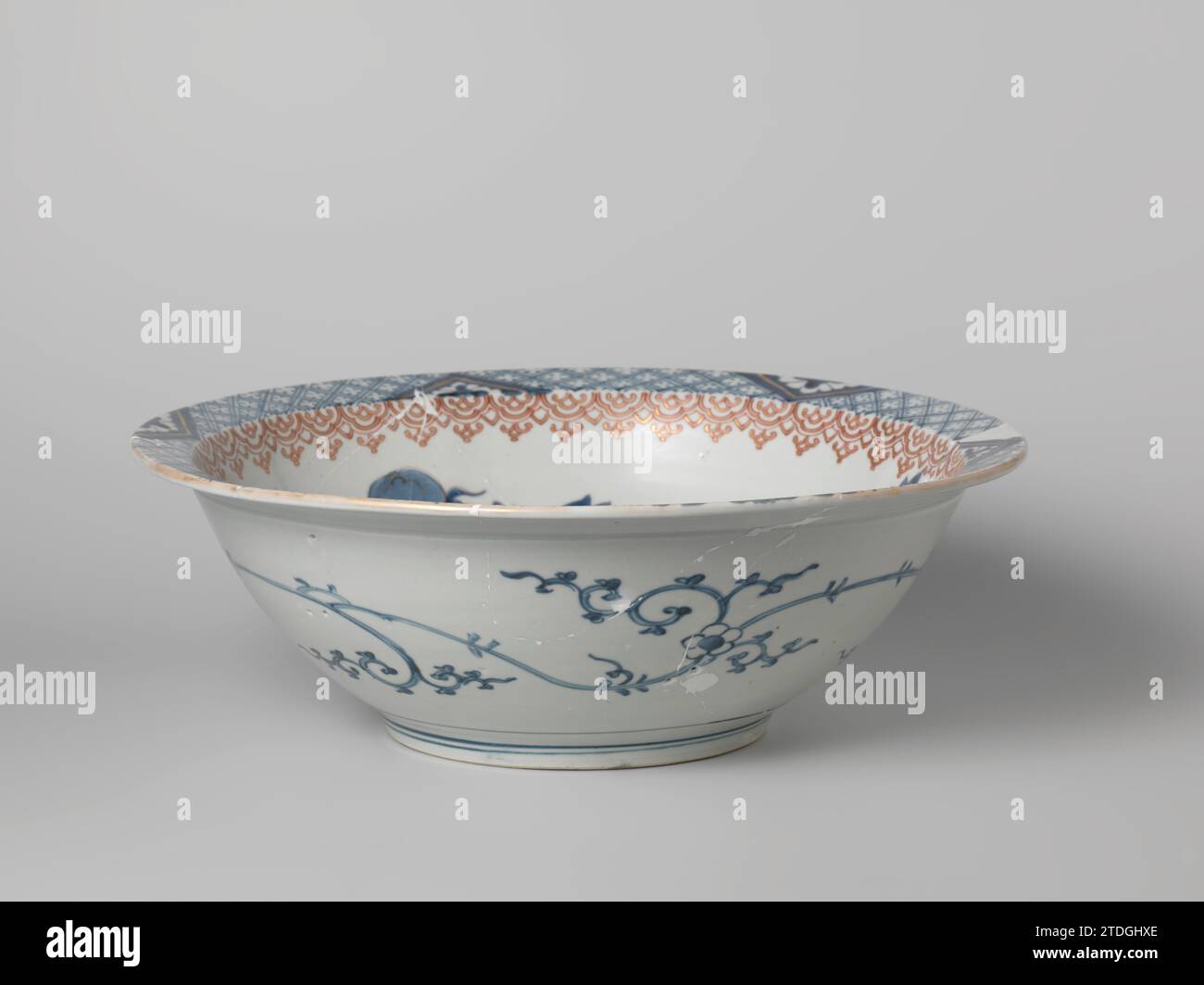 Ciotola con shishi e farfalla vicino a un ramo di peonia, anonimo, c. 1675 - c. 1725 grande ciotola di Porslein con bordo piatto, dipinta in blu trasparente e sul rosso e oro glassa. L'interno con uno shishi (cane da leone) e una farfalla su un ramo di torba; il muro con una banda con motivi Ruyi. Il bordo interno con il servizio interrotto da triangoli con un fiore stilizzato salvato. Una bevanda floreale continua sulla parete esterna. La ciotola è rotta. Imari. Porcellana giapponese. glassa. cobalto (minerale). Pittura oro (metallo) / doratura / vitrificazione grande ciotola di Porslein con bordo piatto, verniciata in Foto Stock