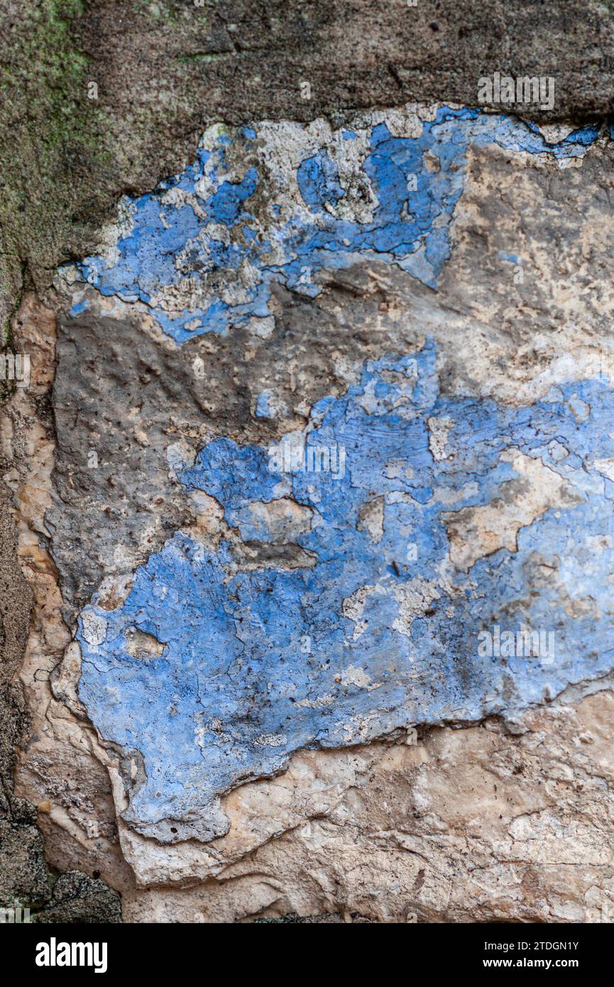 Dettaglio astratto primo piano di un muro di pietra con sbucciatura, vernice blu e verde incrinata e cementazione su un vecchio edificio a Gerusalemme, Israele. Foto Stock