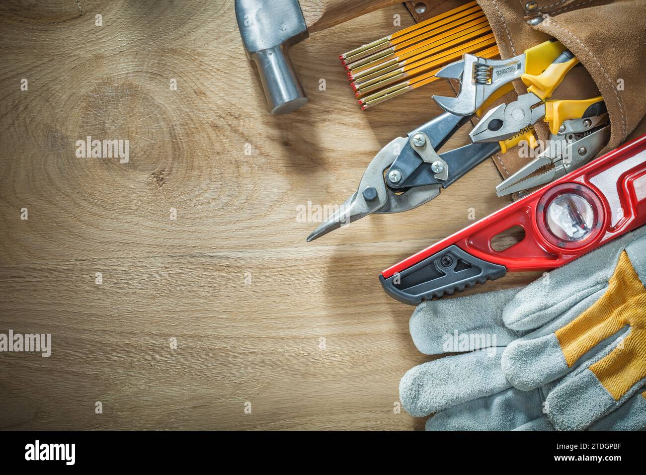 Set di utensili da costruzione in cintura portautensili in pelle su tavola di legno Foto Stock