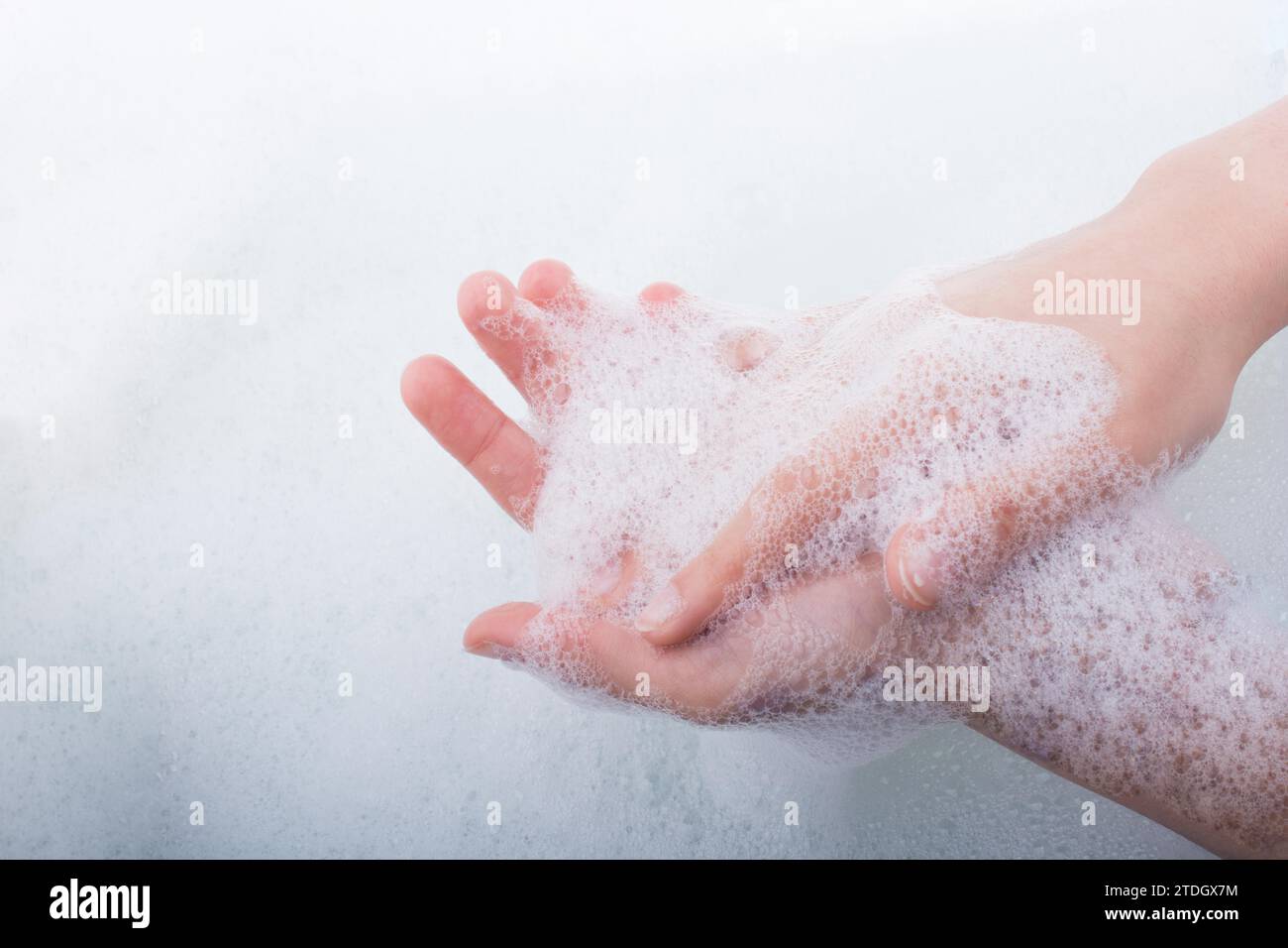 Lavaggio a mano e schiuma di sapone su un sfondo schiumoso Foto Stock