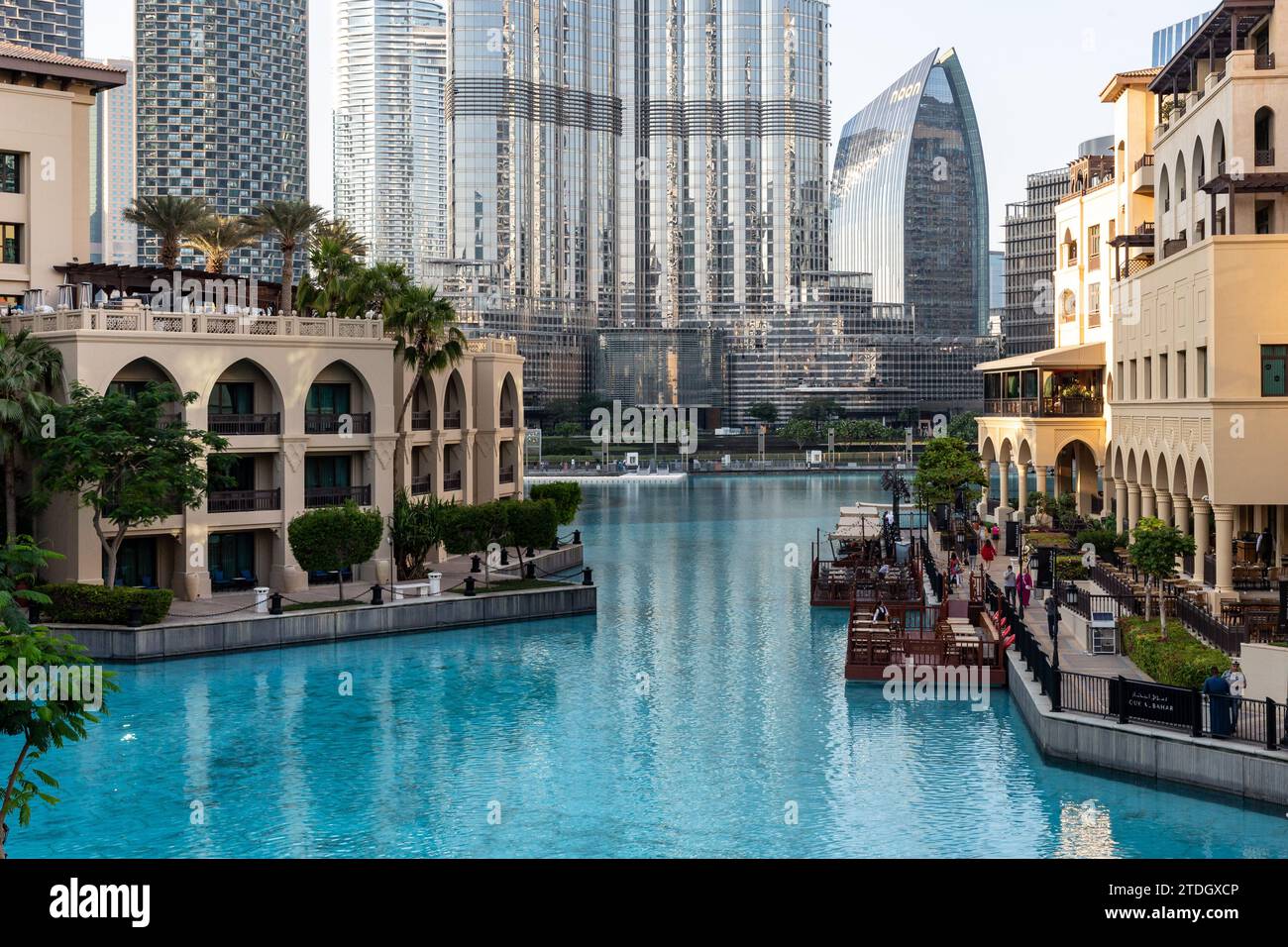 Dubai, Emirati Arabi Uniti. 18 dicembre 2023. Gli edifici della città vecchia di Dubai, il Souk al Bahar e l'architettura moderna del centro della città, tra cui il Burj Khalifa, si vedono contro l'acqua della Fontana di Dubai in un caldo giorno di dicembre. Credito: Dominika Zarzycka/Alamy Live News Foto Stock