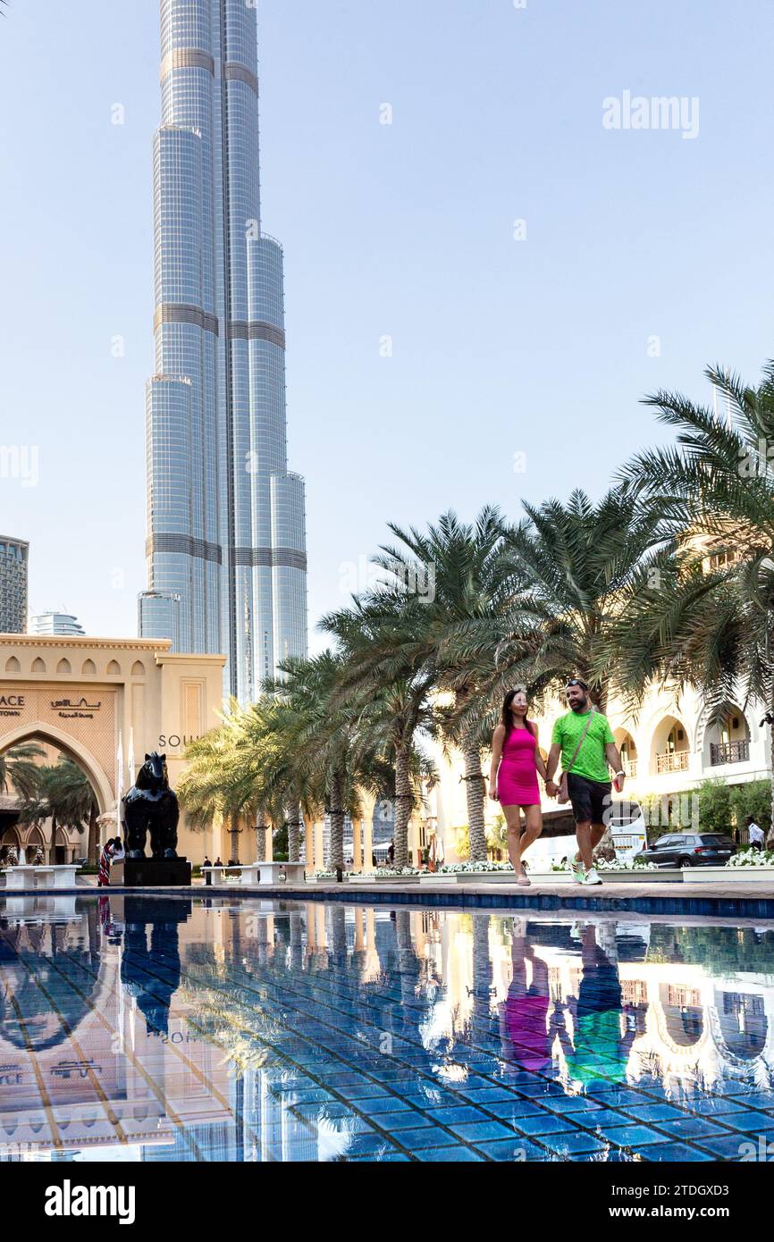 Dubai, Emirati Arabi Uniti. 18 dicembre 2023. Un paio di passeggiate in piscina di fronte alla torre Burj Khalifa in un caldo giorno di dicembre nel centro di Dubai. Credito: Dominika Zarzycka/Alamy Live News Foto Stock