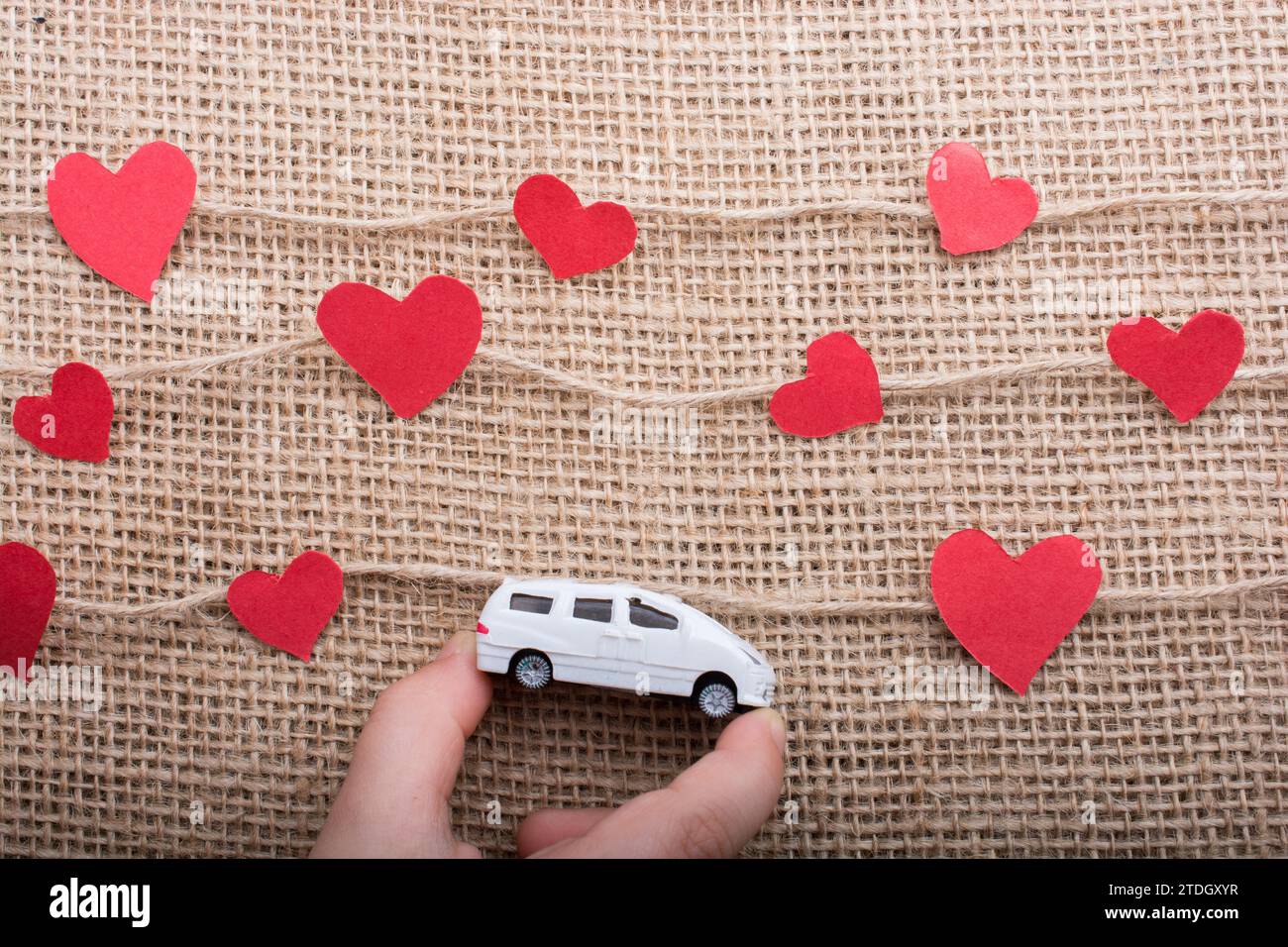 Il concetto di amore con auto e cuore della carta su filati di lino Foto Stock