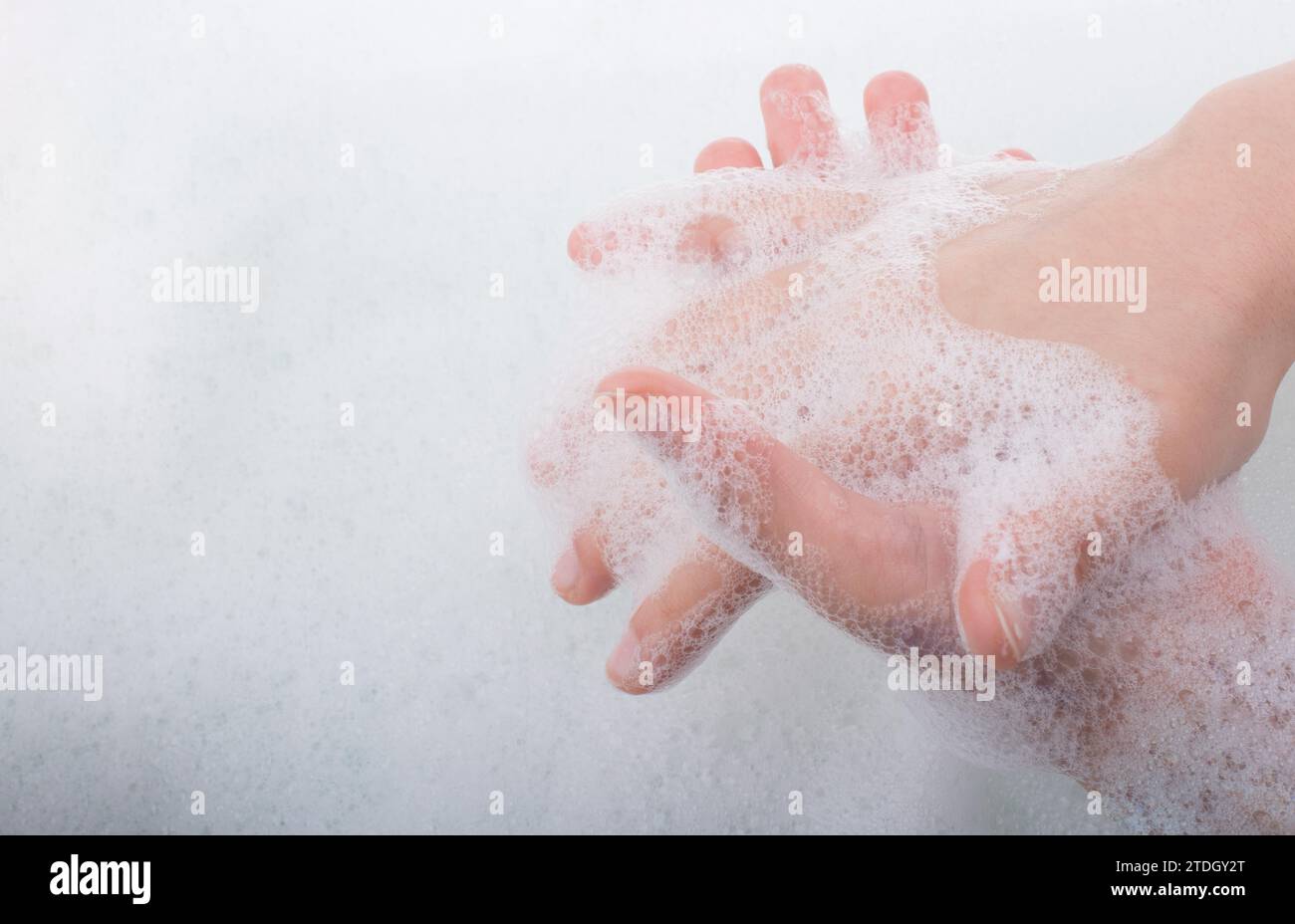 Lavaggio a mano e schiuma di sapone su un sfondo schiumoso Foto Stock