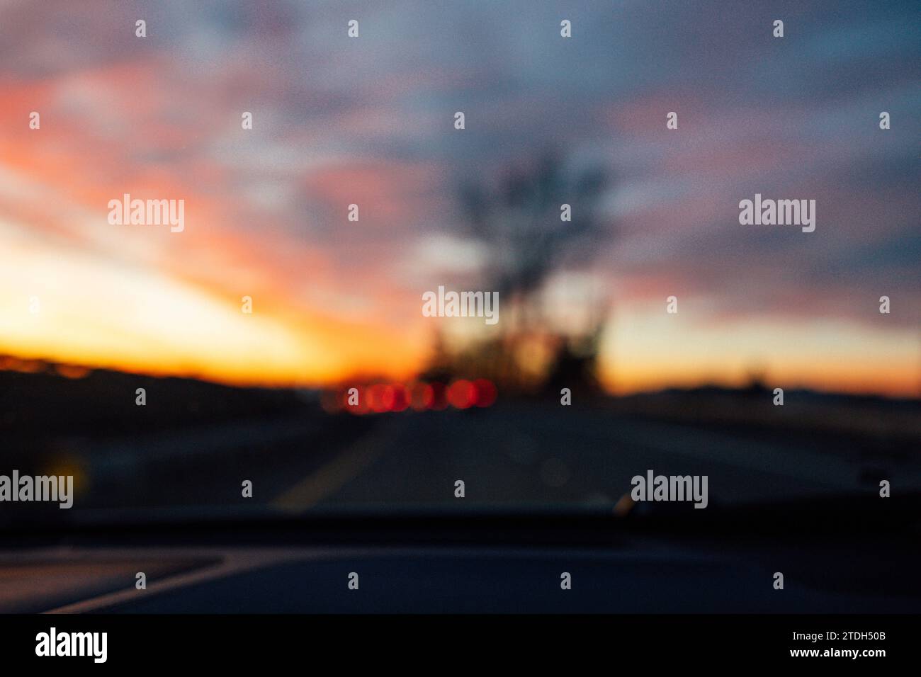 vista sfocata della guida in autostrada durante un tramonto spettacolare in inverno, al crepuscolo Foto Stock