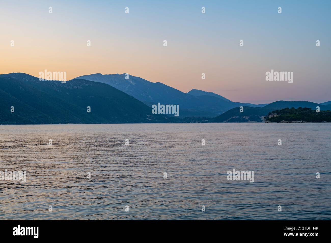 Tramonto dietro l'isola greca di Lefkada da Agios Ioannis su Meganisi nel Mar Ionio Foto Stock