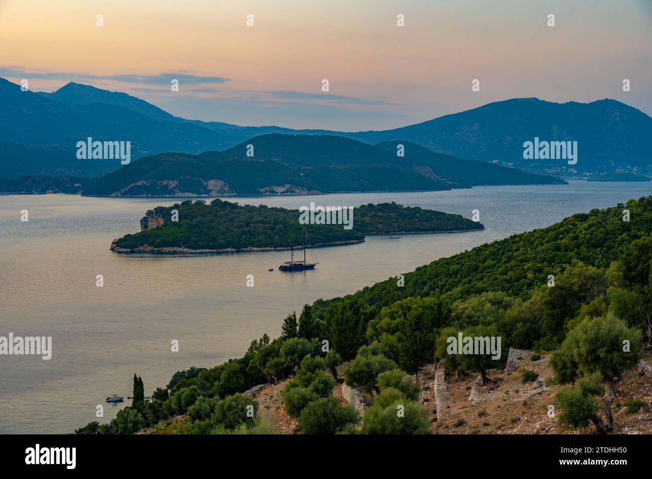 Tramonto dietro l'isola greca di Lefkada e Nisída Thiliá dalla strada sopra Agios Ioannis a Meganisi nel Mar Ionio Foto Stock