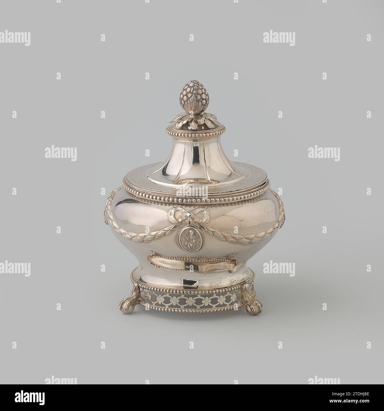 Macchia di tabacco, rotonda, decorata con ghirlande imposte e medaglioni, con coperchio sciolto, Wouterus Verschuur (argentiere), 1791 il macchia rotonda di tabacco ha un coperchio sciolto e poggia su tre zampe fuse a forma di artiglio di uccello su una sfera. Le gambe sono fissate a un bordo di apertura ovale collegato da rosette lungo il lato inferiore del corpo, chiuso in alto e in basso da un bordo perlato. Il corpo è leggermente ristretto dal basso e a volta sopra di esso. Ha decorato un basso bordo della bocca dritto con una lista di perle. Viene guidato tutto intorno con una Bay garland, che è attaccata a un anello su entrambi i lati Foto Stock