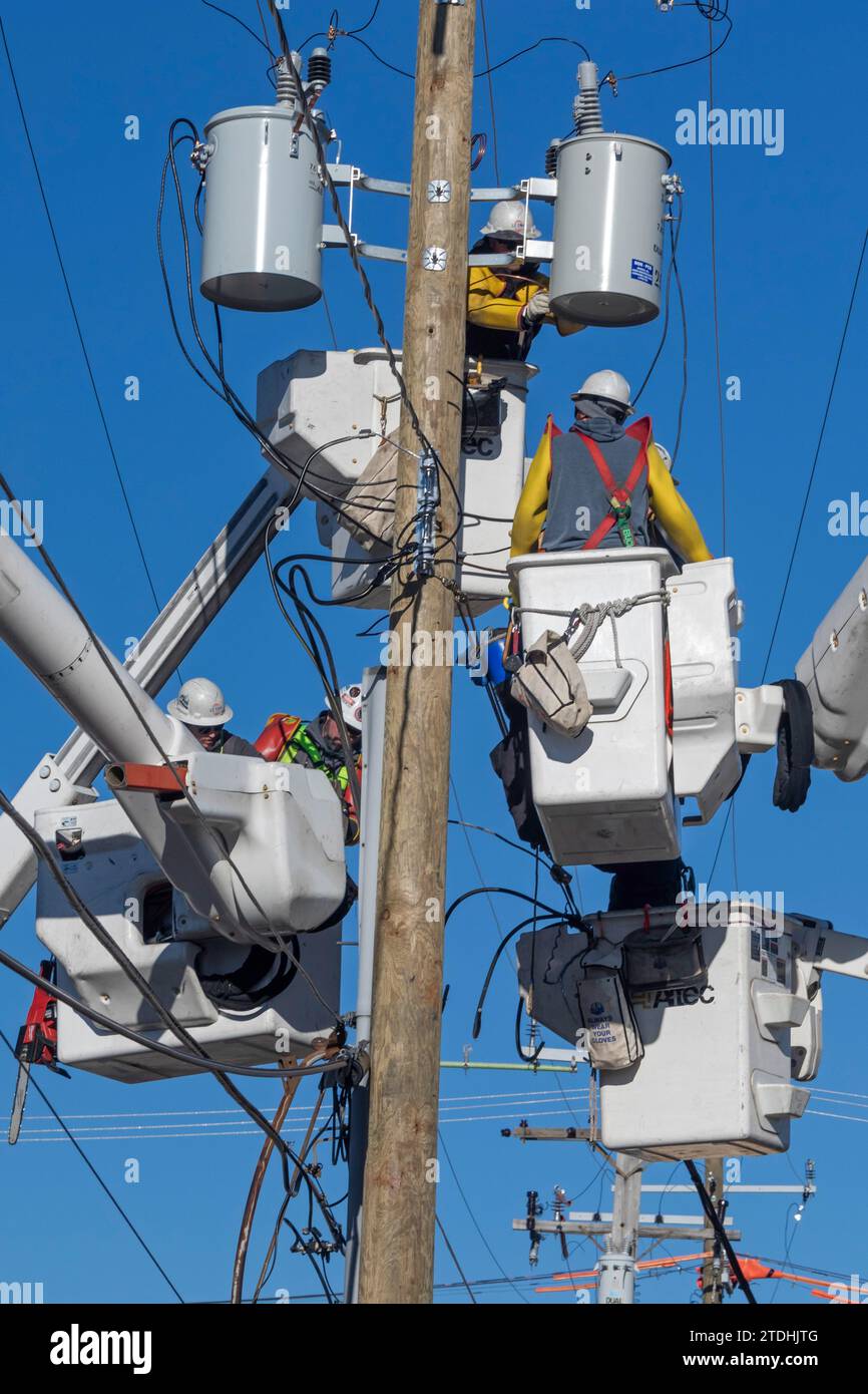 Detroit, Michigan - gli addetti alla linea elettrica, che lavorano per DTE Energy, sostituiscono le apparecchiature di trasmissione su un palo elettrico. Foto Stock