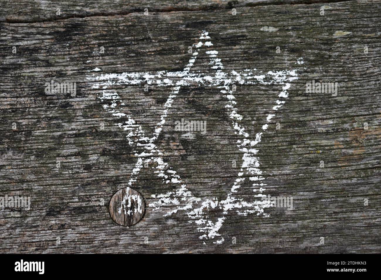 Una Stella ebraica di David disegnata in gesso bianco su una superficie di legno intemprata Foto Stock