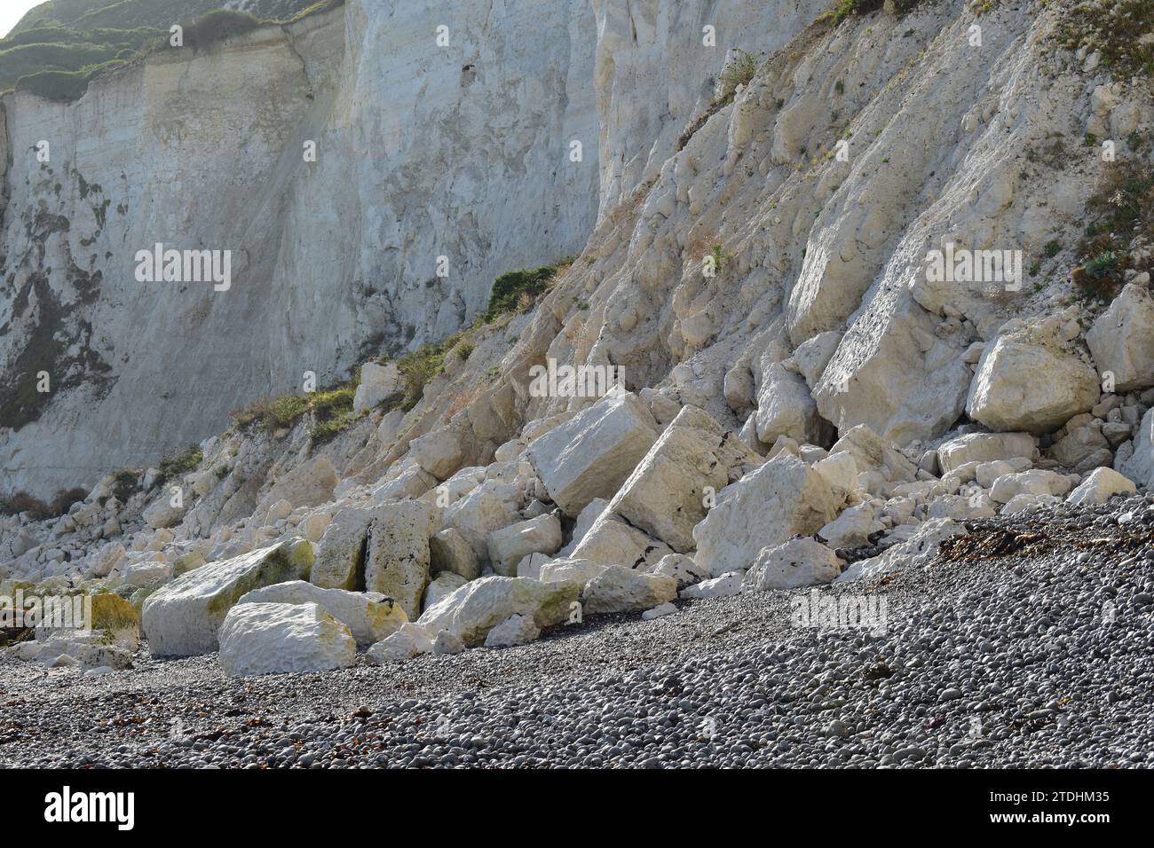 Massi di pietra e rocce bianche in gesso sulla spiaggia alla base delle bianche scogliere di dover Foto Stock