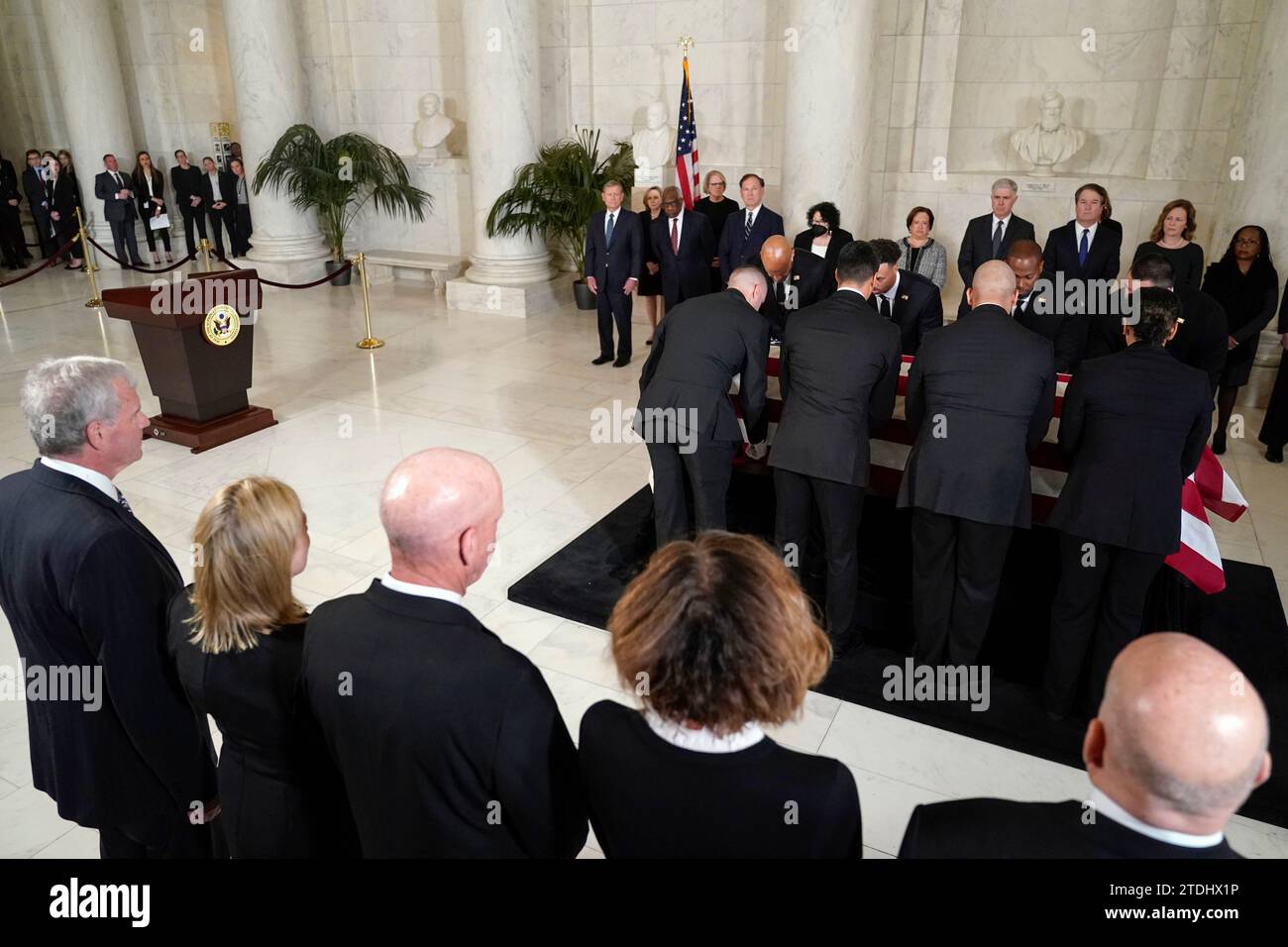 Gli ufficiali della polizia della Corte Suprema degli Stati Uniti collocano lo scrigno drappeggiato dalla bandiera del giudice della Corte Suprema in pensione Sandra Day o'Connor sul Lincoln Catafalque di fronte a un servizio privato nella Great Hall alla Corte Suprema di Washington, lunedì 18 dicembre 2023. A guardare da sinistra ci sono John G. Roberts, Jr., giudici associati della Corte Suprema Clarence Thomas, Samuel alito, Sonia Sotomayor Elena Kagan, Neil Gorsuch, Brett Kavanaugh, Amy Coney Barrett e Ketanji Brown Jackson. Justice o'Connor, nativa dell'Arizona, la prima donna a servire nella più alta nazione Foto Stock