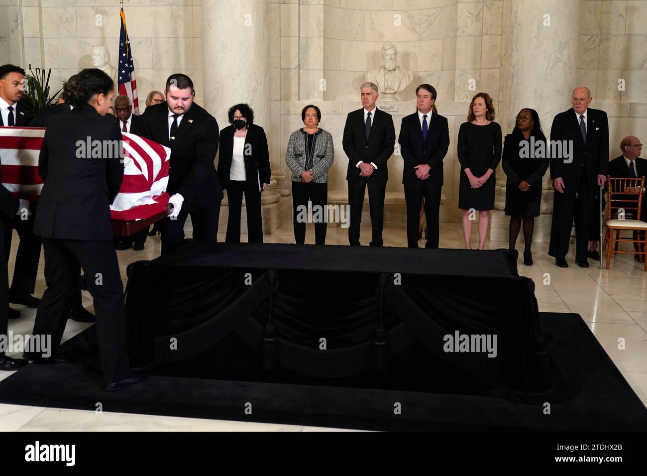 Gli ufficiali della polizia della Corte Suprema degli Stati Uniti collocano lo scrigno drappeggiato dalla bandiera del giudice della Corte Suprema in pensione Sandra Day o'Connor sul Lincoln Catafalque di fronte a un servizio privato nella Great Hall alla Corte Suprema di Washington, lunedì 18 dicembre 2023. A guardare da sinistra ci sono i giudici associati della Corte Suprema Clarence Thomas, Samuel alito, Sonia Sotomayor Elena Kagan, Neil Gorsuch, Brett Kavanaugh, Amy Coney Barrett, Ketanji Brown Jackson e il giudice in pensione Anthony Kennedy.Justice o'Connor, nativo dell'Arizona, la prima donna a servire nella corte più alta della nazione, servita da 1981 unt Foto Stock