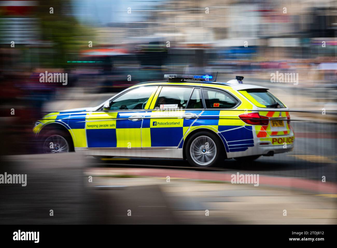 Motion Photo - Una Blue Light Police Scotland BMW 330D Police Car attraversa Princes Street, Edimburgo, Scozia, Regno Unito. Risposta di emergenza Foto Stock