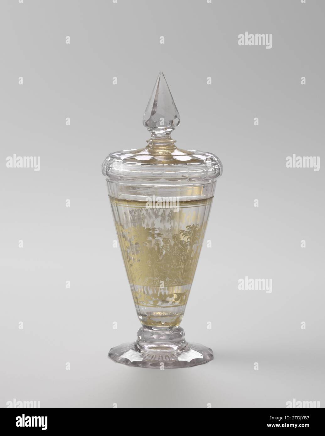 Coppa a piedi con coperchio di Zwischengoldglas, Anonimo, c. 1720 - c. 1740 piede conico leggero con decorazione tagliata. Disco sfaccettato, sfaccettato più volte, calice conico. Sul calice, sopra un bordo stilizzato foglie, in oro foglia e incisione, una fontana con un delfino che respira l'acqua per una balaustra con vasi da giardino, una scena valorosa e una parete giardino cinese con un cesto di fiori. Con coperchio in dotazione (BK-NM-10754-269-2). Vetro Boemia soffiante/macinatura piede conico chiaro con decorazione tagliata. Disco sfaccettato, sfaccettato più volte, calice conico. Sul calice, sopra un bordo stilizzato lea Foto Stock