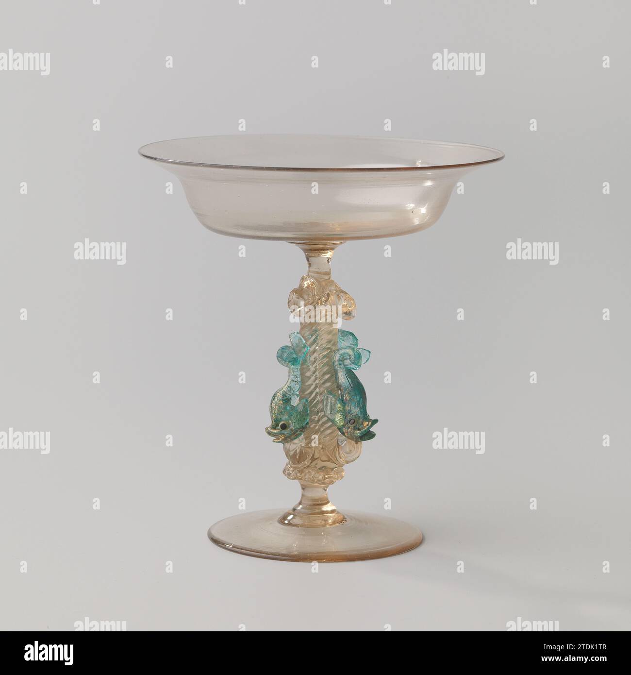 Tazza con tronco con tre delfini, anonimi, c. 1800 - c. 1900 piatto. Stam composto da tre fili intrecciati. Su ogni filo un delfino di vetro blu con doratura; occhi di vetro verde e nero. Calice a forma di scala con ampio bordo piegato. Vetro di Venezia. Doratura (materiale) vetro soffiato / doratura piatta. Stam composto da tre fili intrecciati. Su ogni filo un delfino di vetro blu con doratura; occhi di vetro verde e nero. Calice a forma di scala con ampio bordo piegato. Vetro di Venezia. doratura (materiale) soffiatura/doratura del vetro Foto Stock