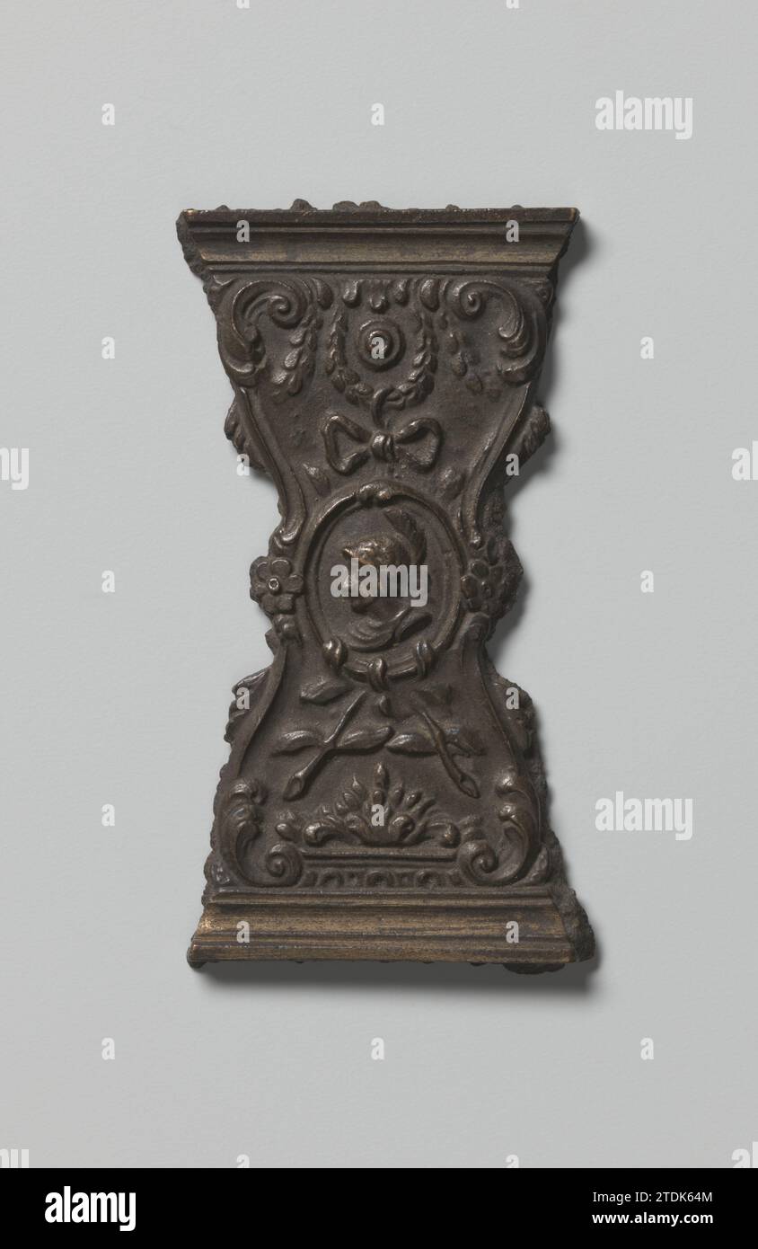 Modello per una staffa di una serratura a libro con un medaglione con un involucro da minatore, anonimo, c. 1750 - c. 1775 il modello fuso per uno stampo è dotato di un medaglione appeso a una ghirlanda, di un arco e di rami con la testa di Minerva, tutto circondato da altri ornamenti. Rame di Amsterdam (metallo) il modello fuso per uno stampo è dotato di un medaglione appeso a una ghirlanda, un arco e rami con la testa di Minerva, il tutto circondato da altri ornamenti. Amsterdam rame (metallo) Foto Stock