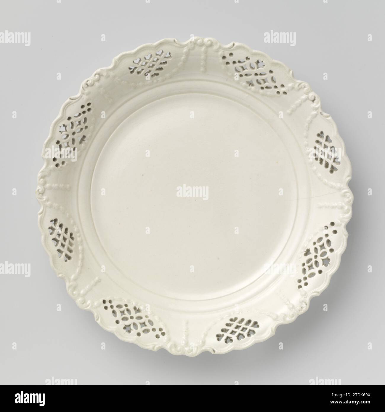 Scala di frutta di terracotta dura, con bordo traforato, cremosa., Anonimo, c. 1780 - c. 1820 recipiente di frutta rotonda di ceramica cotta dura, con bordo traforato. Garandes e festoni corrono in rilievo tra i medaglioni a traforo. La scala appartiene a tre scale uguali con invnr. DA BK-NM-11010-A A BK-NM-11010-D. Terracotta inglese ciotola di frutta rotonda di ceramica cotta duramente, con bordo apribile. Garandes e festoni corrono in rilievo tra i medaglioni a traforo. La scala appartiene a tre scale uguali con invnr. DA BK-NM-11010-A A BK-NM-11010-D. Terracotta per l'Inghilterra Foto Stock