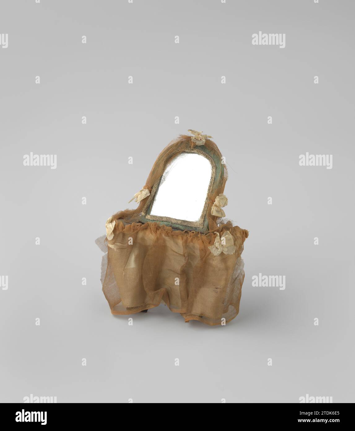 Tavolo WC, rivestito di seta bianca e blu e rete, c. 1750 il tavolo è composto da un piano fisso laccato nero, su cui è posto uno specchio, sostenuto da una barra di legno. Il piano del tavolo e lo specchio sono ricoperti di seta blu, rifiniti con cinghia bianca. Intorno al tavolo c'è un tappeto tintinnato di seta e rete, un panno di rete è drappeggiato intorno allo specchio; cinque archi di seta adornano gli angoli delle foglie e dello specchio. Amsterdam (forse) cartone. legno (materiale vegetale). seta. Occhiali da vista il tavolino da toilette è composto da un ripiano su una base laccata fissa nera, su cui si trova Foto Stock