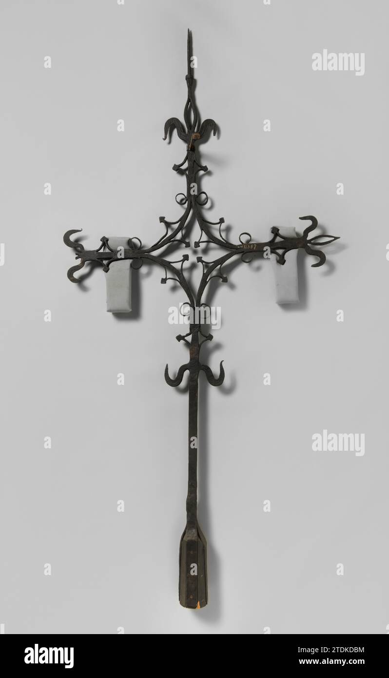 Croce della torre la cui intersezione è stata forgiata in una finestra in cui un quadrifoglio. Stam è decorato con ricci, c. 1400 - c. 1950 Una croce di ferro forgiata (da una guglia o faglia del tetto) su una forcella, intorno alla quale una testa di ferro Koniano (?) Il tronco è decorato con vari ricci andati, l'incrocio forgiato in una finestra in cui una foglia di trifoglio. I bracci trasversali finiscono con un giglio. Lo scontrino è sottile e arrotondato come perno per una paletta del vento. Manca la paletta del vento. Ferro (metallo) Una croce di ferro forgiata (da una guglia o un guasto del tetto) su una forcella, attorno alla quale una testa di ferro Konian (?) Il tronco e' decorato con vari scomparsi Foto Stock