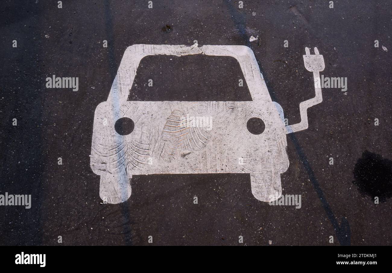 Hannover, Germania. 19 dicembre 2023. Un simbolo su un parcheggio indica un impianto di ricarica per auto elettriche. Dopo l'improvvisa fine del premio di acquisto per le auto elettriche, i clienti ora guardano in basso. L'industria protesta e si lamenta di una perdita di fiducia nella politica. Nell'ambito del loro programma di austerità, alcuni giorni fa i leader della coalizione SPD, Verdi e FDP hanno concordato di eliminare gradualmente le sovvenzioni statali "prontamente”. Credito: Julian Stratenschulte/dpa/Alamy Live News Foto Stock