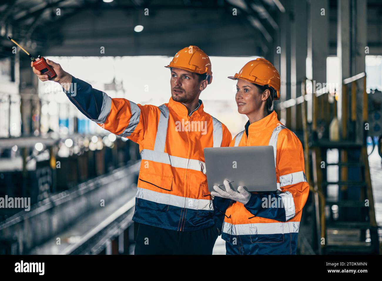 Ingegnere addetto alla sicurezza uomo e donna che lavorano insieme con il controllo del computer portatile ispezionare in fabbrica di costruzioni industriali pesanti. Foto Stock