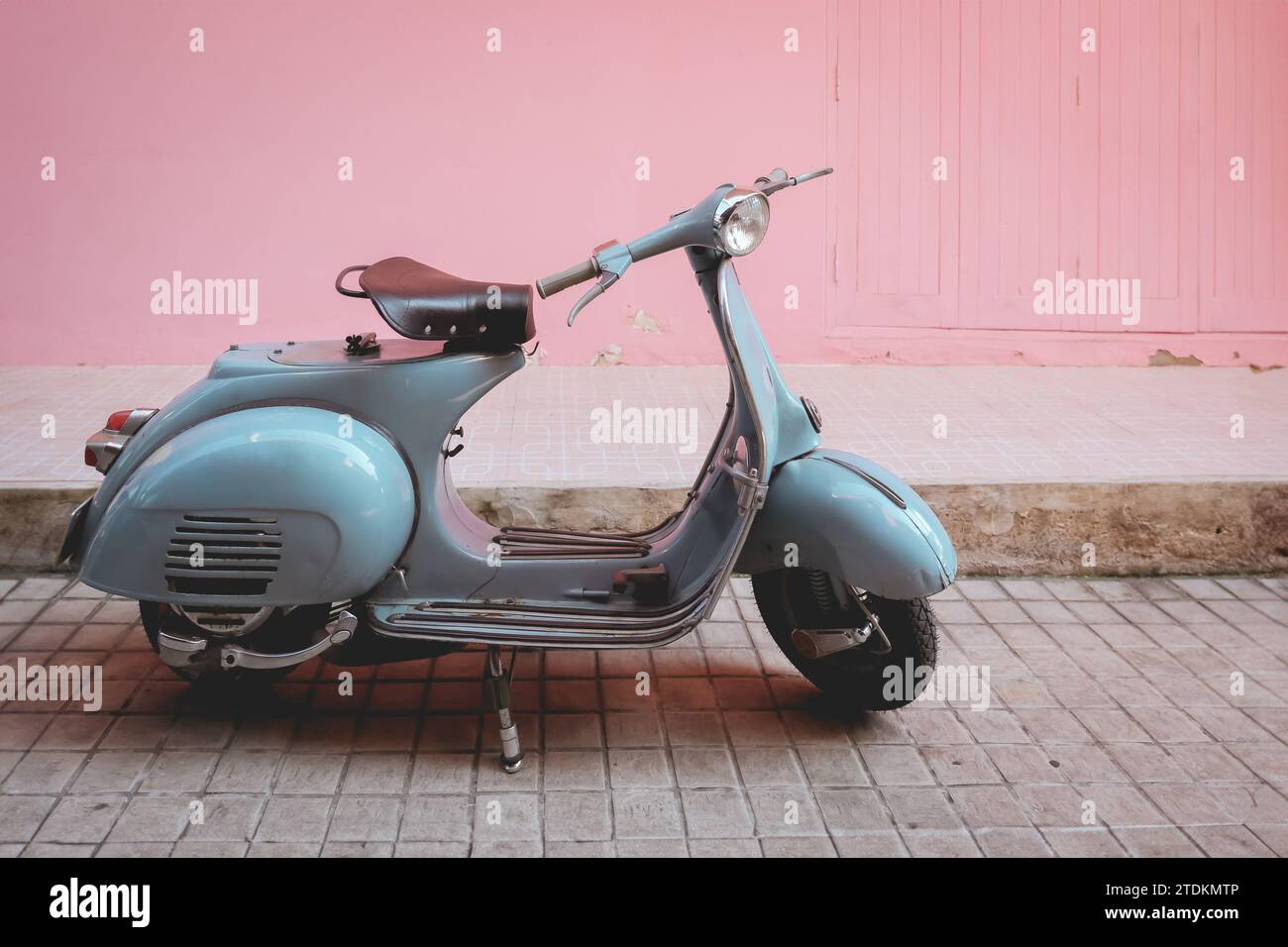 vecchio parcheggio in stile moto d'epoca classico e retrò in stile scooter sulla parete rosa della strada cittadina Foto Stock