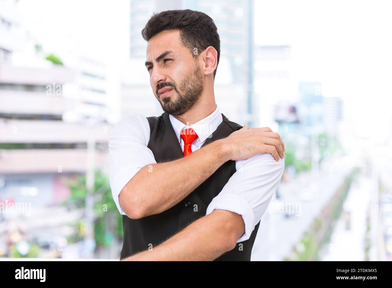 Ispanico indiano uomo d'affari dolore alla spalla muscolo del braccio si uniscono crampi dalla sindrome dell'ufficio dopo una dura giornata di lavoro. Foto Stock