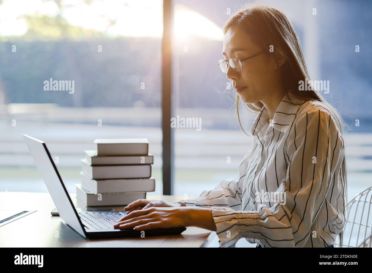Donna d'affari asiatica cinese adulta seduta, studio di lavoro, ricerca di teoria aziendale in un luogo accogliente con computer portatile wireless Foto Stock