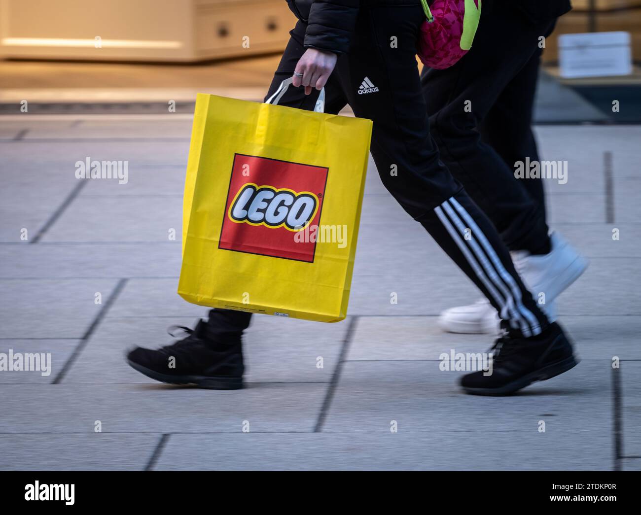 13 dicembre 2023, Assia, Francoforte sul meno: Un passante trasporta una borsa di Lego lungo la via dello shopping Zeil di Francoforte. Foto: Frank Rumpenhorst/dpa Foto Stock