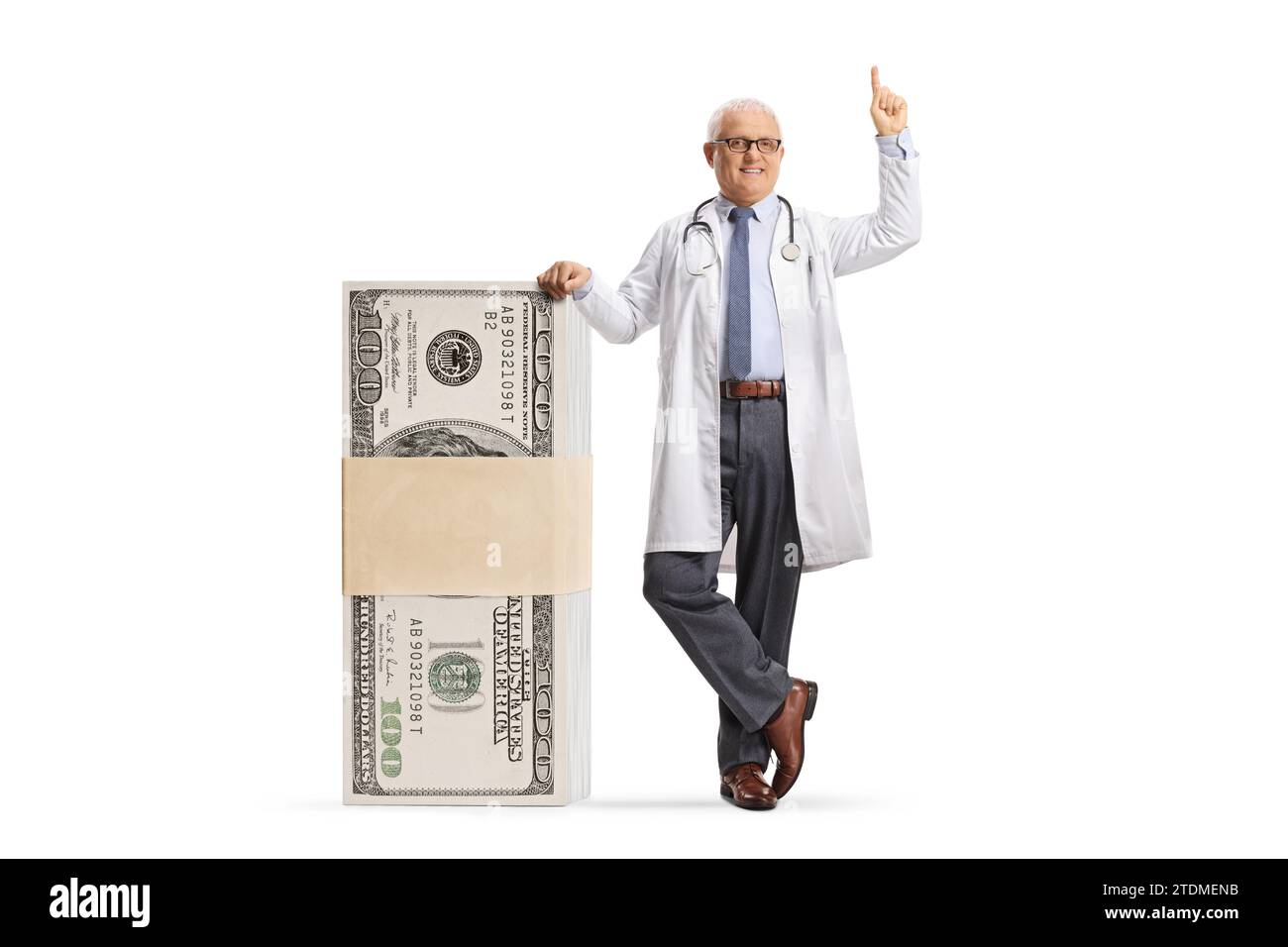 Medico maschio appoggiato su una pila di soldi e puntato verso l'alto isolato su sfondo bianco Foto Stock