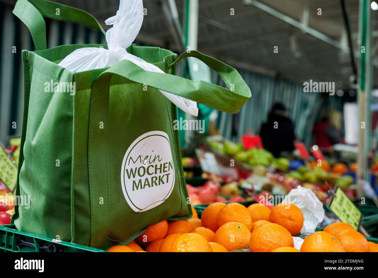Stand auf einem Wochenmarkt. Auf einer Orangenkiste steht eine Grüne Aunkaufstasche aus Stoff. Foto Stock