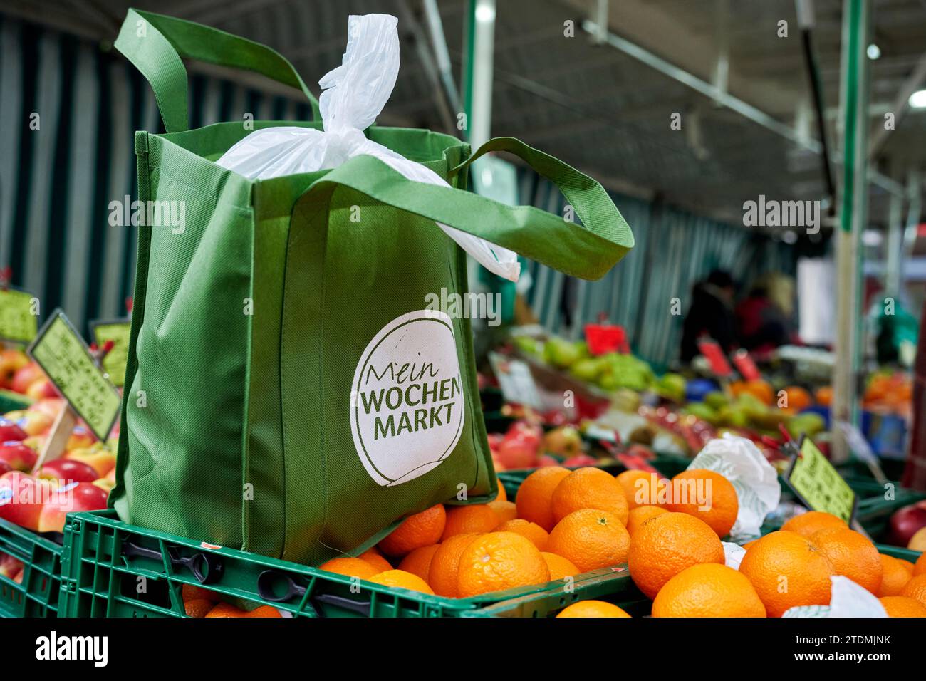 Stand auf einem Wochenmarkt. Auf einer Orangenkiste steht eine Grüne Aunkaufstasche aus Stoff. Foto Stock